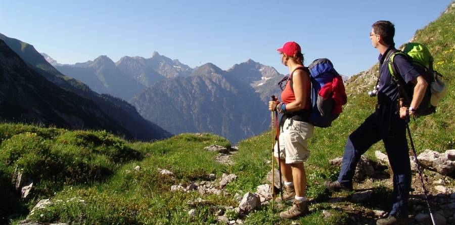 Teilnehmerin einer Alpenüberquerung genießt den Blick