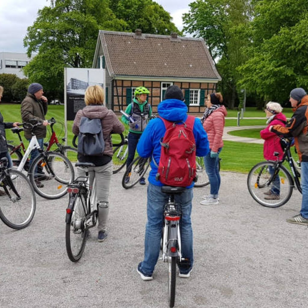 Radfahrer hören ihrem Guide bei einer Pause in einem Park zu