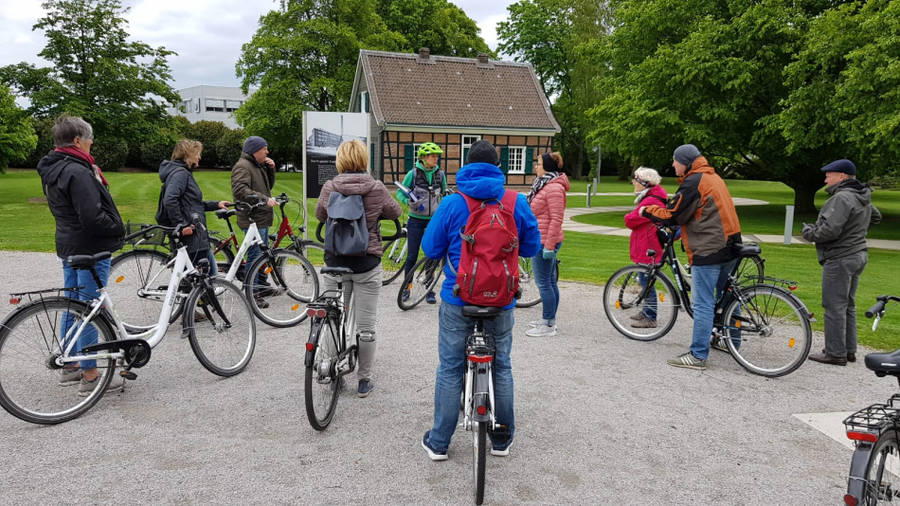 Radfahrer hören ihrem Guide bei einer Pause in einem Park zu